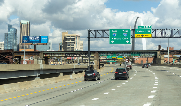Highway in St. Louis, Missouri, with overhead signs for I-70 and I-44 and the Gateway Arch visible in the background.