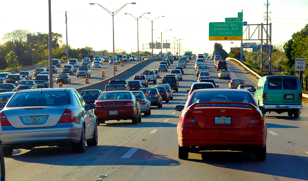 Heavy daytime traffic on I-275 in Tampa, Florida, showing multiple lanes of cars approaching an overhead green highway sign for Howard and Armenia Avenue.