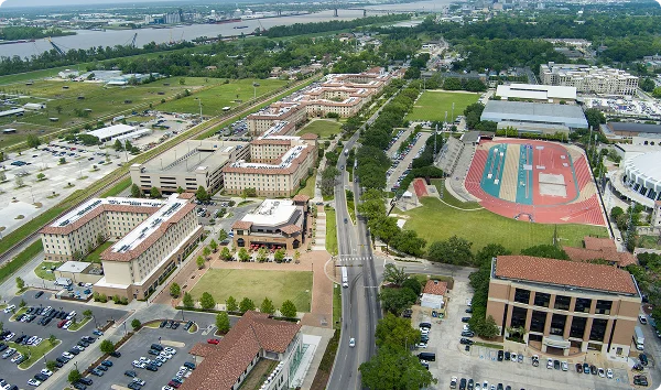 An aerial shot of the Louisiana State University campus and the Mississippi River with cars on the street and lush green trees and grass in Baton Rouge Louisiana USA.